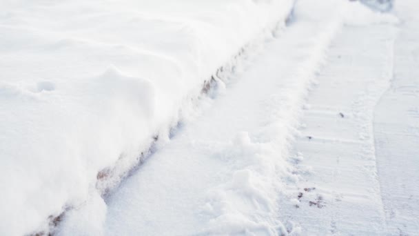 Een man schept sneeuw van een pad in slow motion. Komt in beeld — Stockvideo
