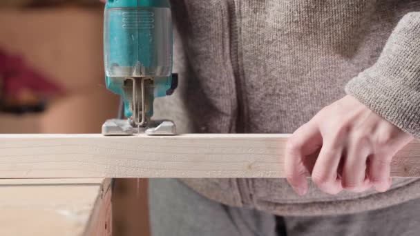 Un tipo corta una viga de madera con un rompecabezas, de cerca — Vídeo de stock