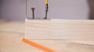 Çapraz başlı bir tornavida, metal bir köşeyi takmak için tahta bir çubuğu vidaladı.