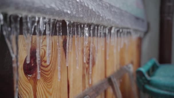 Hanging ice icicles close-up in winter outdoors — Stockvideo