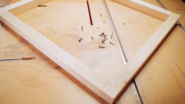 Black self-tapping screws fall on a wooden table in slow motion inside a wooden structure — Vídeo de Stock