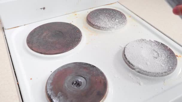 Spraying a dirty kitchen electric stove with white foam of a good detergent — Video Stock