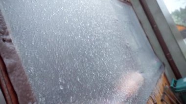 Close-up iced glass of summer terrace after freezing rain