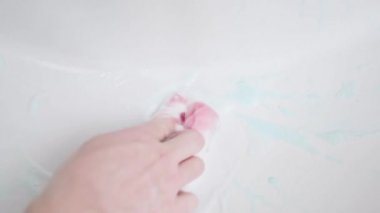 Washing the drain hole of the sink with a sponge and detergent close-up