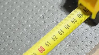 Kalemle yoğun köpüğün uzunluğunu yakın plan şeritle işaretliyorum. Yalıtım malzemesi işaretleme