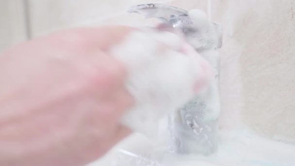 Het wassen van een glanzende kraan close-up met een spons en schuimig wasmiddel — Stockvideo