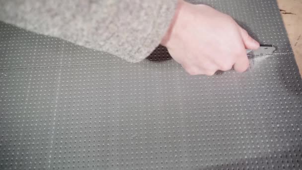 En hand skär ett tjockt isoleringsskum med kniv, ovanifrån — Stockvideo