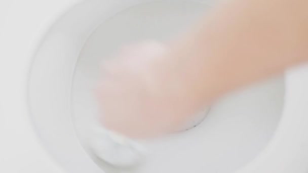 Hand reinigt een toiletpot met een borstel close-up, bovenaanzicht — Stockvideo
