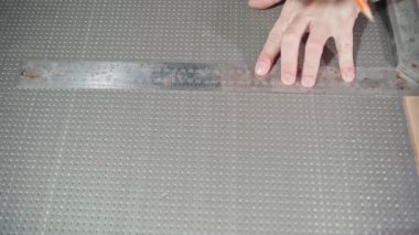 Eller, cetvelin altına gri yoğun köpükle bir çizgi çeker.