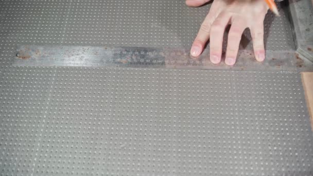 Les mains tracent une ligne avec un crayon sous la règle sur de la mousse dense grise — Video