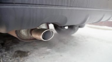 Kışın sıfırın altındaki sıcaklıklarda benzin motorunun soğuk başlangıcı. Isınmamış bir arabanın egzozundan çıkan kalın beyaz dumanın yakın çekimi.
