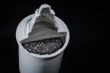 Aktif karbon ve iyon değişim reçineleri içeren bir mutfak filtresi kartuşunun kesilmesi