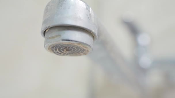 Des gouttes d'eau coulent du timon d'un robinet dans la salle de bain. Dépôts blancs sur la plomberie gros plan. Fuite de mélangeur de robinet — Video