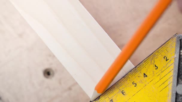 Pomiar dokładnych wymiarów i oznaczenia ołówkiem przed cięciem drewnianych belek. Stosując kwadrat dla linii prostych i kąta prostego — Wideo stockowe