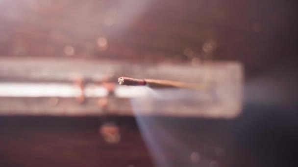 The smoke from the incense stick flies into the frame, top view — Stock Video