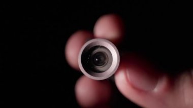 Ellerdeki küçük bir kamera modülü karanlıkta kayboluyor.