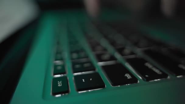 Mains tapant sur un clavier d'ordinateur portable dans l'obscurité. Rétroéclairage couleur — Video