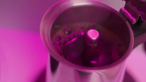 El café listo hierve y hierve en una cafetera de géiser bajo iluminación rosa — Vídeos de Stock