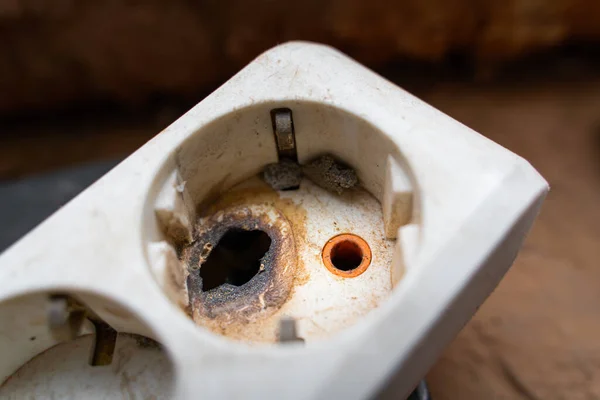 Düşük kalite elektrik konnektörü. Güvenlik kurallarına uymamaktan. Yakılmış ve erimiş çıkış deliği. Yakın plan.
