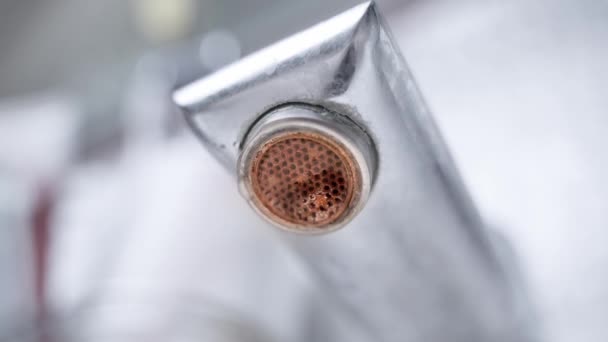 Gotas de água gotejamento de uma torneira de banheiro enferrujado, close-up. Vista inferior de uma malha de torneira de água coberta com vaporização e corrosão — Vídeo de Stock