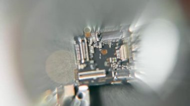 Kiev, Ukrayna - 17 Ocak 2022: Bir elma akıllı telefonunun elektronik devre kartını büyüteç altında incelemek