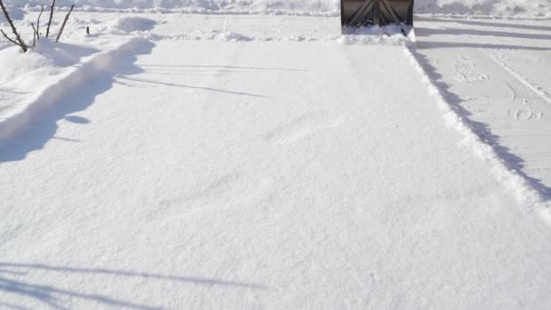 用铲子扔雪.这家伙在阳光充足的天气里清扫雪地 — 图库视频影像