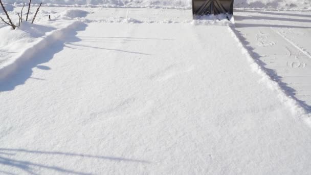 Tirando nieve con una pala. El tipo limpia la nieve en un clima soleado — Vídeos de Stock