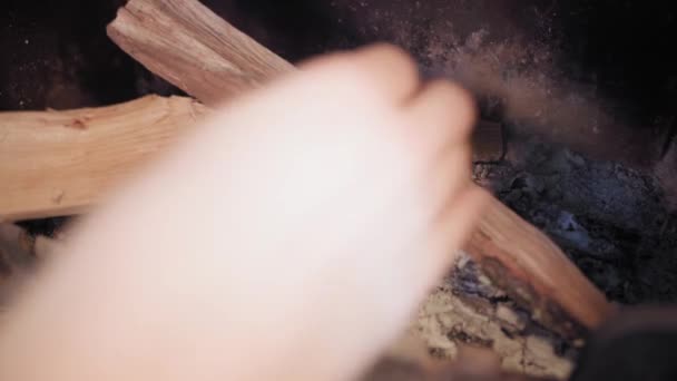 Mãos empilhar lenha em uma lareira para iniciar um incêndio, close-up — Vídeo de Stock