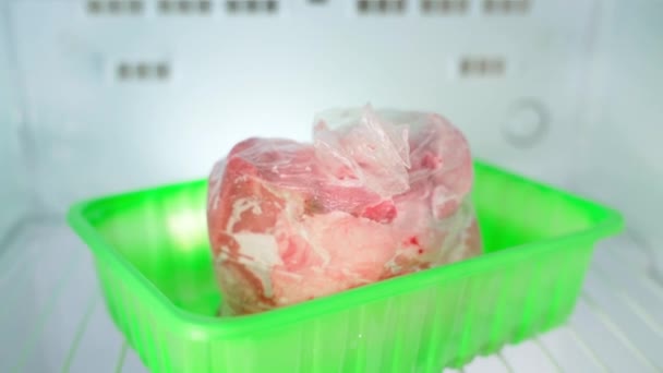 Carne congelada cruda en una bolsa de plástico en el congelador — Vídeo de stock