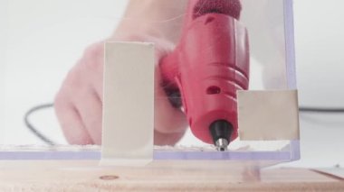 Cam bir barı yapıştırıcı tabancasıyla yapıştırmak, yakın plan.