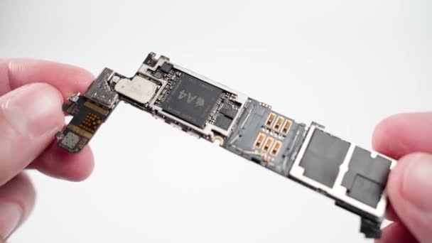 Kiev, Ukraine - January 16, 2022: Apple iphone central control electronic board with a4 processor close up on white background — Stock Video