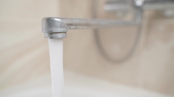 Water flows from a dirty faucet in the bathroom close-up — Stock Video