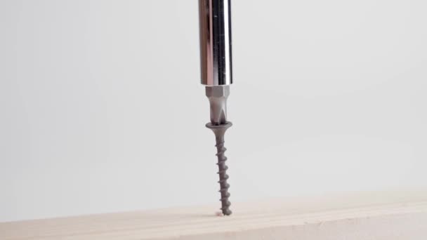 Nahaufnahme einer schwarzen selbstschneidenden Schraube, die mit einem Phillips-Schraubendreher in einen Holzbalken getrieben wird. Selbstschneidende Schraube ging beim Drehen bergab — Stockvideo