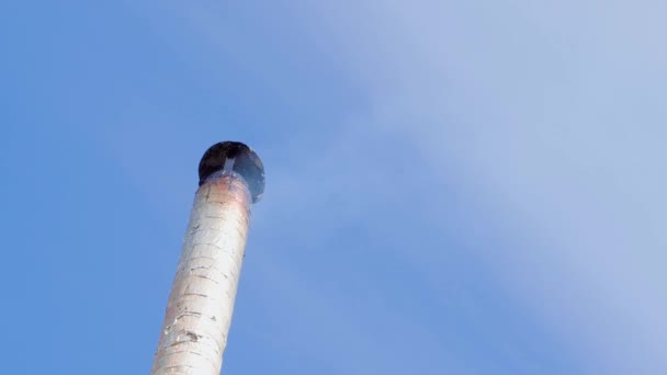 Il fumo viene dal camino di una casa privata contro un cielo blu — Video Stock