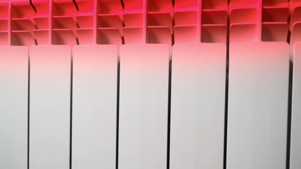 Bimetallischer Heizkörper, der auf Rot erhitzt wird. Wärmeabgabe eines Wasserstrahlers in einem Raum — Stockvideo