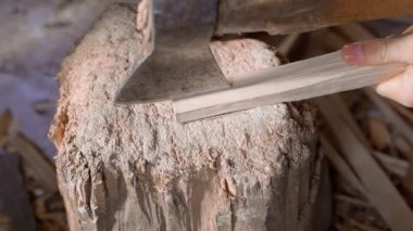 Yakacak odunları baltayla ince parçalara ayırmak, yakın plan.