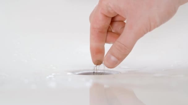 Main tire les cheveux et la saleté du drain de la salle de bain — Video