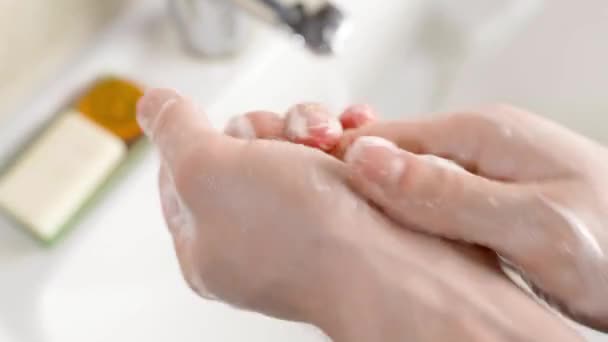 Тщательное мытье рук с мылом крупным планом на фоне раковины в ванной комнате — стоковое видео
