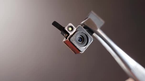 Nahaufnahme-Kameramodul mit Blitz vom Telefon in der Zange. Mikroskopische Videokamera — Stockvideo