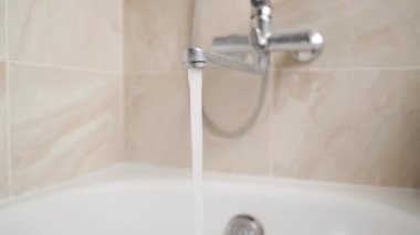 Banyodaki uzun bir delikten güçlü bir basınçla su akar.