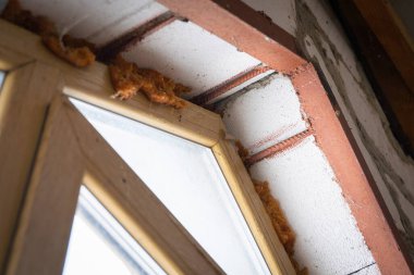 Güçlendirilmiş pencere açılıyor. Havalandırılmış beton bir duvarda tahta taklidi yapılmış plastik pencere.
