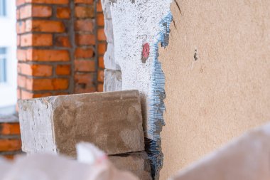 Ön kaplaması soyulmuş özel bir evin duvarı. Yüzü alçı kabuk böceği bej rengine dönük