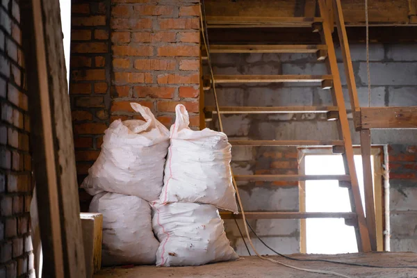 İnşaat alanında enkaz ve atık dolu beyaz çantalar.