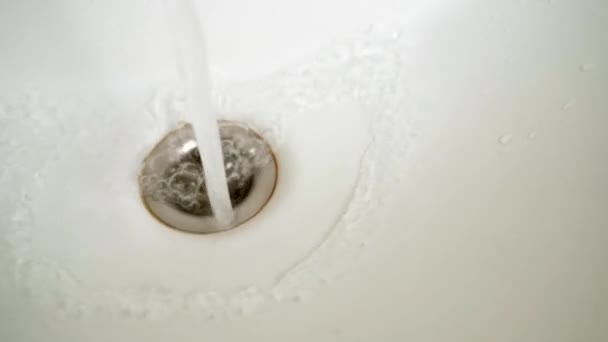 A água flui para o orifício de drenagem do banheiro close-up — Vídeo de Stock