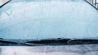 The windshield of the car was covered with frost, outside view