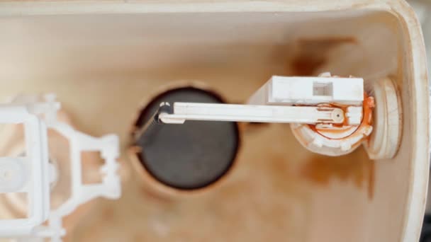 Vanne qui fuit dans la cuvette des toilettes gros plan. Le mécanisme d'alimentation en eau du réservoir — Video