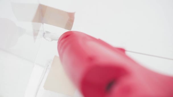 Sealing cracks in glass with a glue gun — стоковое видео