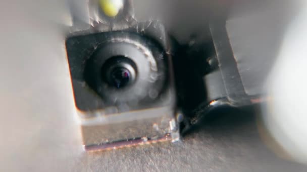 Hidden camera under magnifying glass. Microscopic small video camera module under a magnifying glass close-up. — стоковое видео