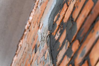 Kablo duvardan geçiyor. Kablolama için ipotek. Taze inşa edilmiş tuğla duvar