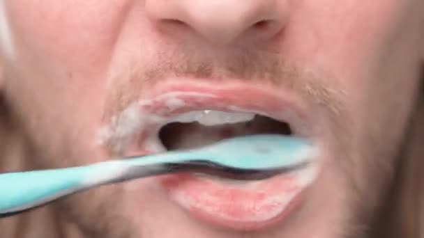 Тщательная чистка зубов крупным планом. Парень показывает зубы после чистки зубной щеткой с зубной пастой — стоковое видео
